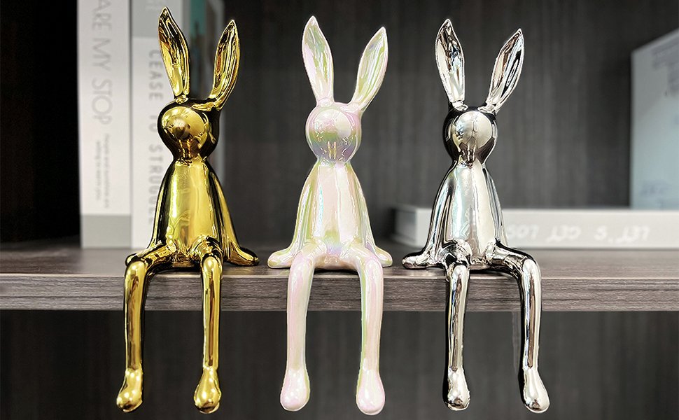 Gold, silver and white bunny decoration sitting on bookshelf